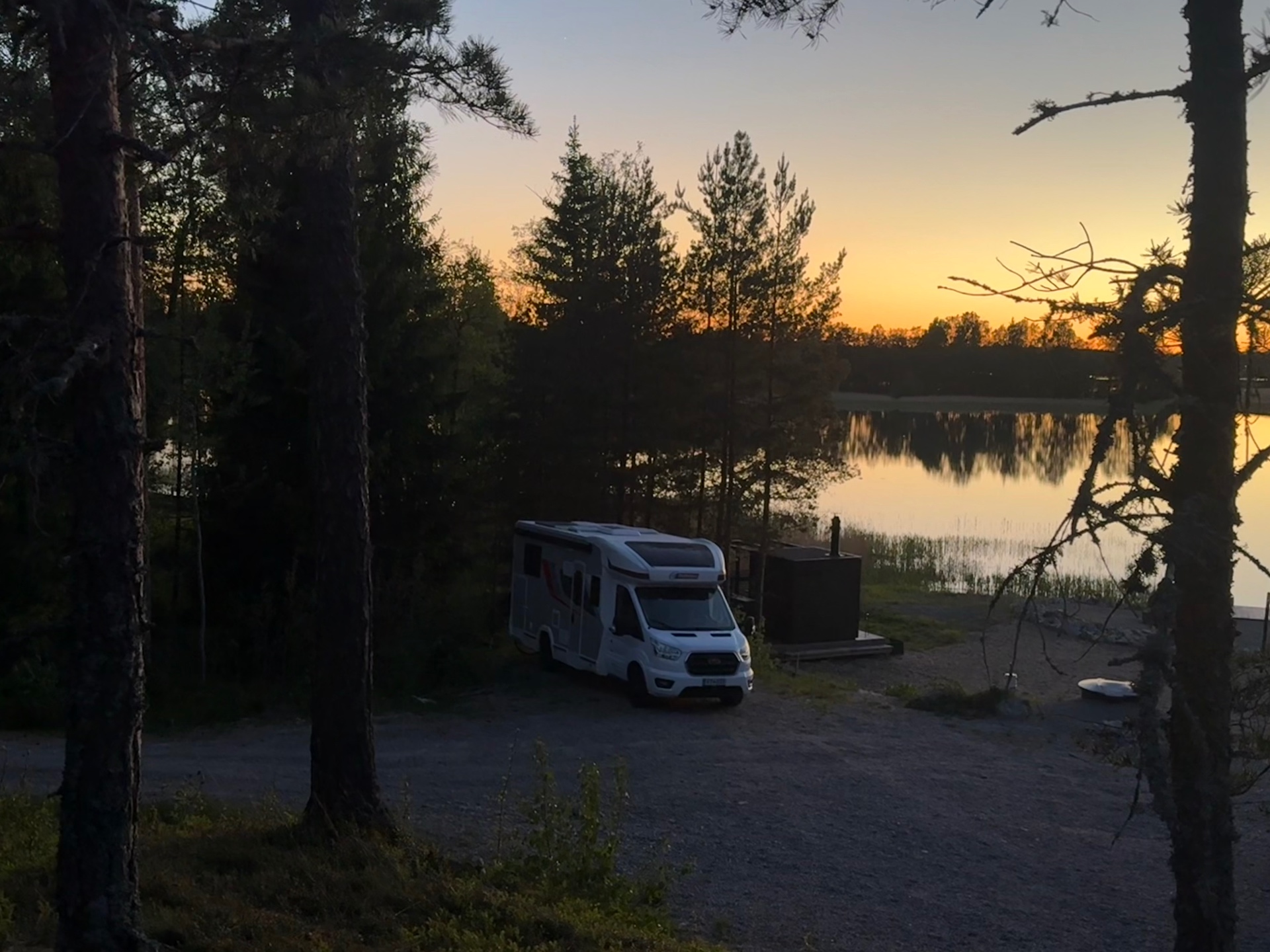 Archivan parked by a still Finnish lake at sunset